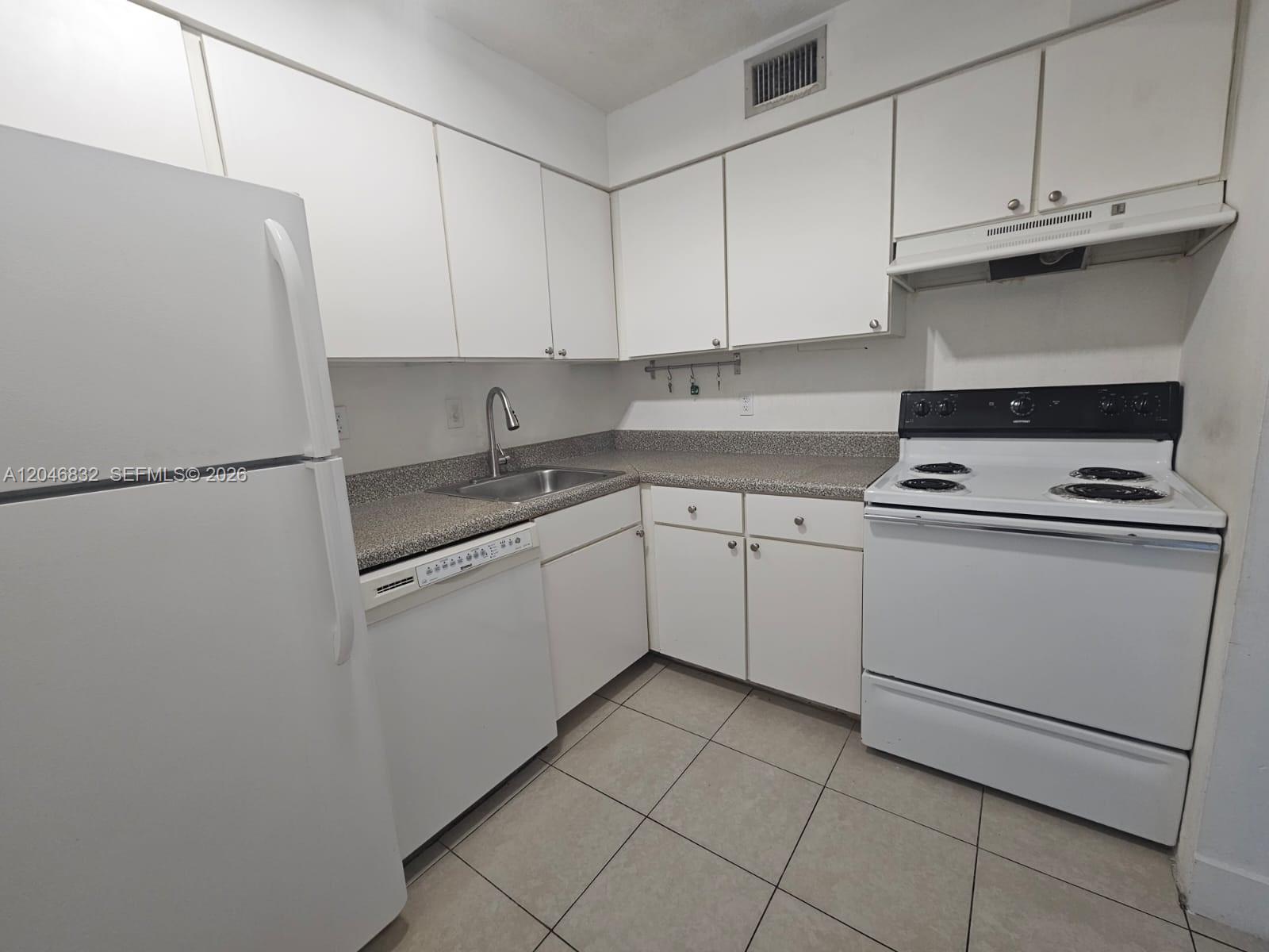 A kitchen features white cabinets, a white refrigerator, a dishwasher, and a white electric stove — 4900 NW 79th Ave # 206, Doral FL 33166, DORAL, FL