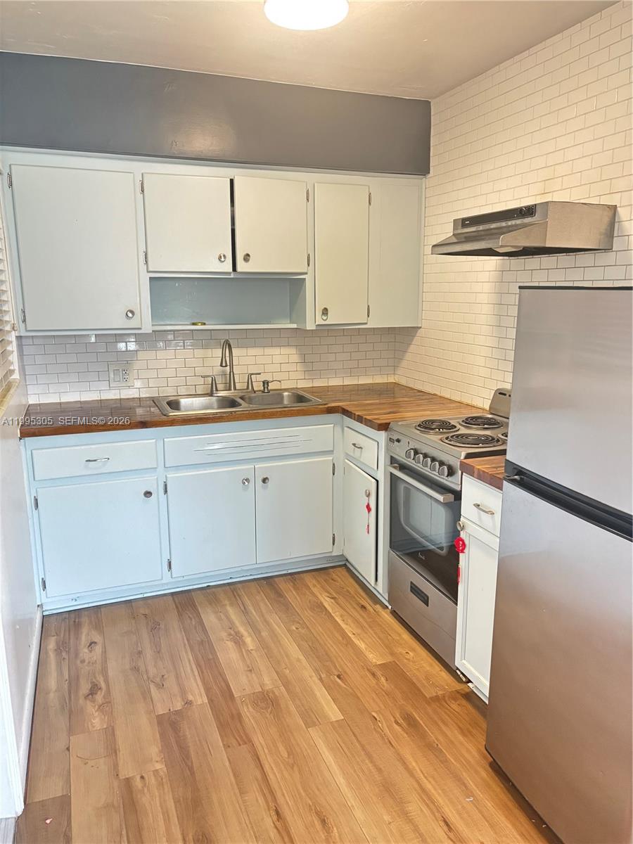 A kitchen features light-colored cabinets, a wood countertop, a stainless steel stove, and subway tile — 2951 SW 23rd St # 2, Miami FL 33145, MIAMI, FL