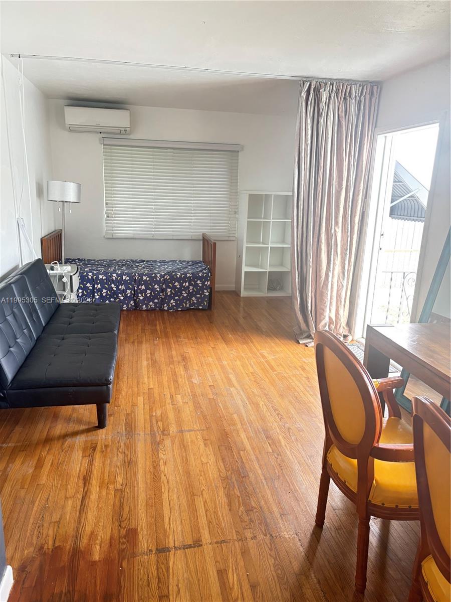 A room with hardwood floors, a black sofa, a twin bed, and a dining set — 2951 SW 23rd St # 2, Miami FL 33145, MIAMI, FL