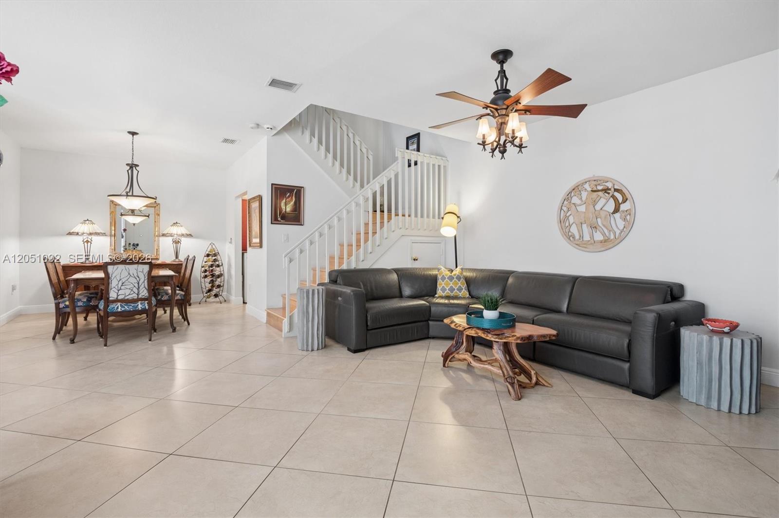 A living room with a gray sectional sofa, a wooden coffee table, and a staircase — 1140 Weeping Willow Way, Hollywood FL 33019, HOLLYWOOD, FL
