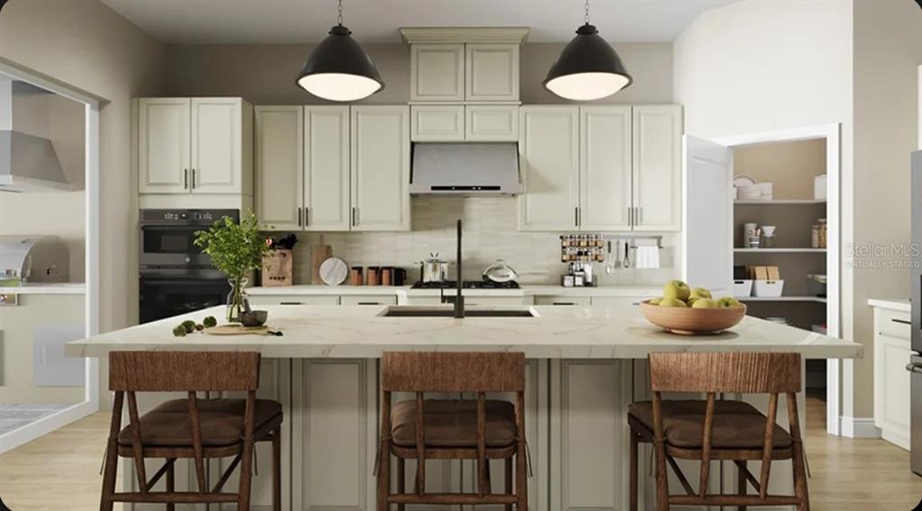 This is a digitally staged kitchen featuring a large island, light cabinetry, and pendant lighting — 13919 IONA AVENUE, PALMETTO, FL