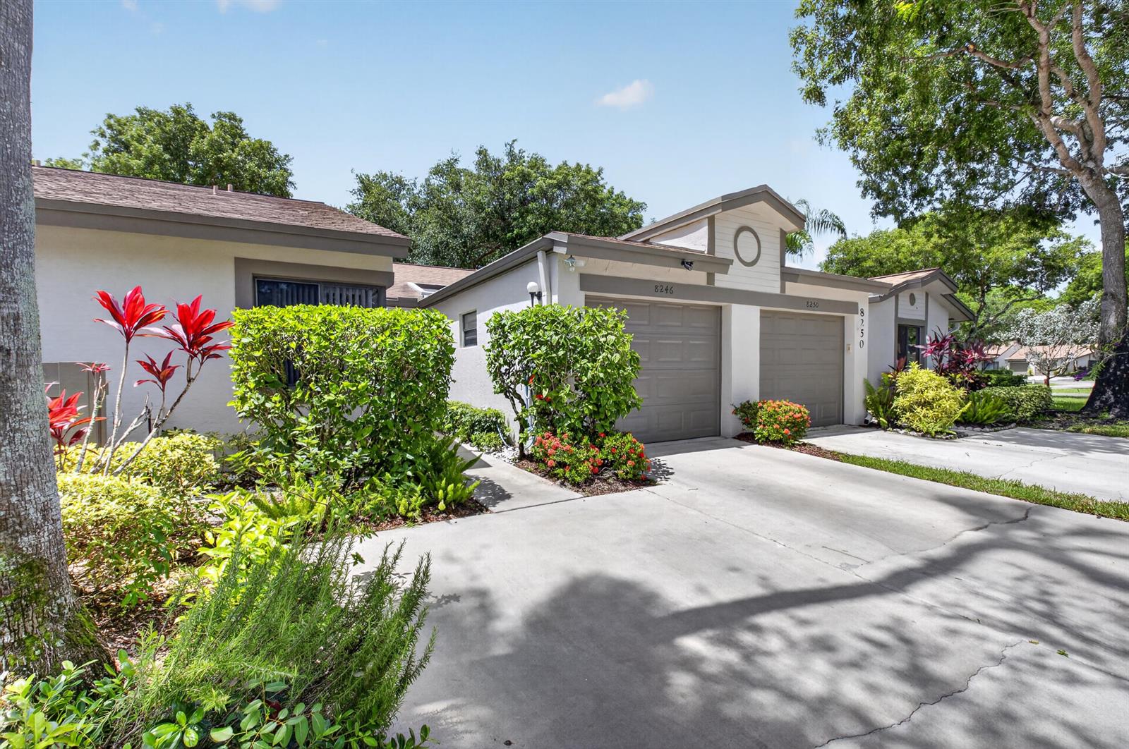 A single-story duplex with two garage doors, light-colored stucco walls, and landscaped front yards — 8246 Springview Terrace, Boca Raton FL 33496, BOCA RATON, FL