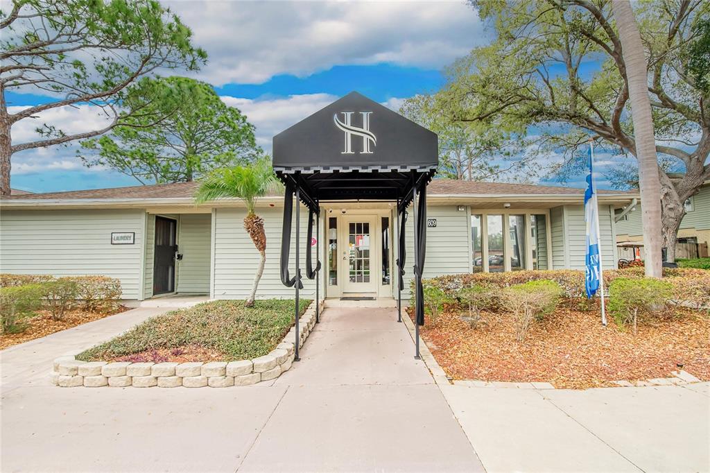 The exterior of a building features a black awning with an H logo over the entrance — 202 RED MAPLE PLACE UNIT 202, BRANDON, FL