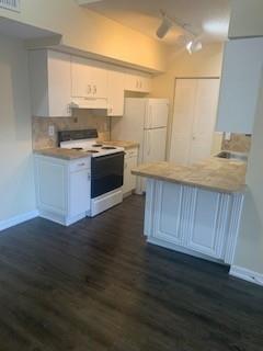 A kitchen features white cabinetry, a black stove, a white refrigerator, and a tiled countertop — 3251 Sabal Palm Manor # 207, Davie FL 33024, DAVIE, FL