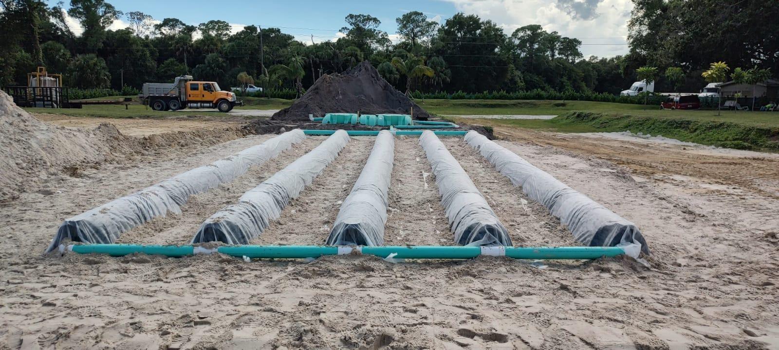 A construction site shows a septic drain field with plastic chambers and green PVC piping — 2516 Us-98 Highway, Okeechobee FL 34972, OKEECHOBEE, FL