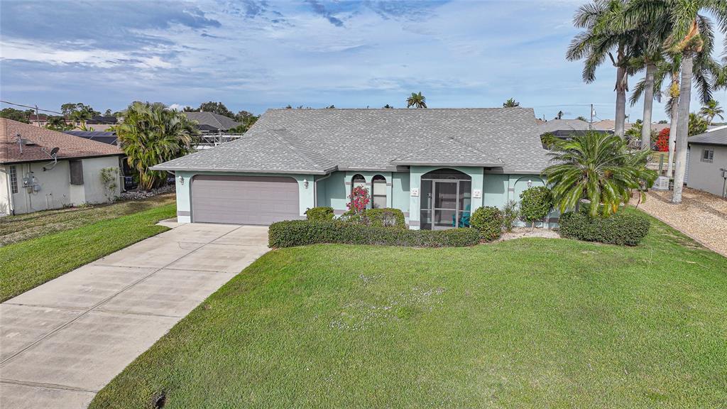A single-story house with a light green exterior, gray roof, and a concrete driveway — 3025 CURRY TERRACE, PORT CHARLOTTE, FL