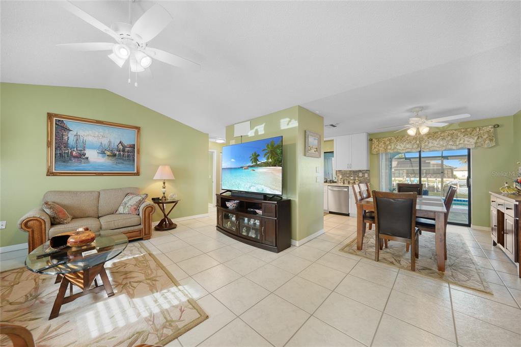 A living room and dining area with tile floors, a ceiling fan, and a television — 3025 CURRY TERRACE, PORT CHARLOTTE, FL