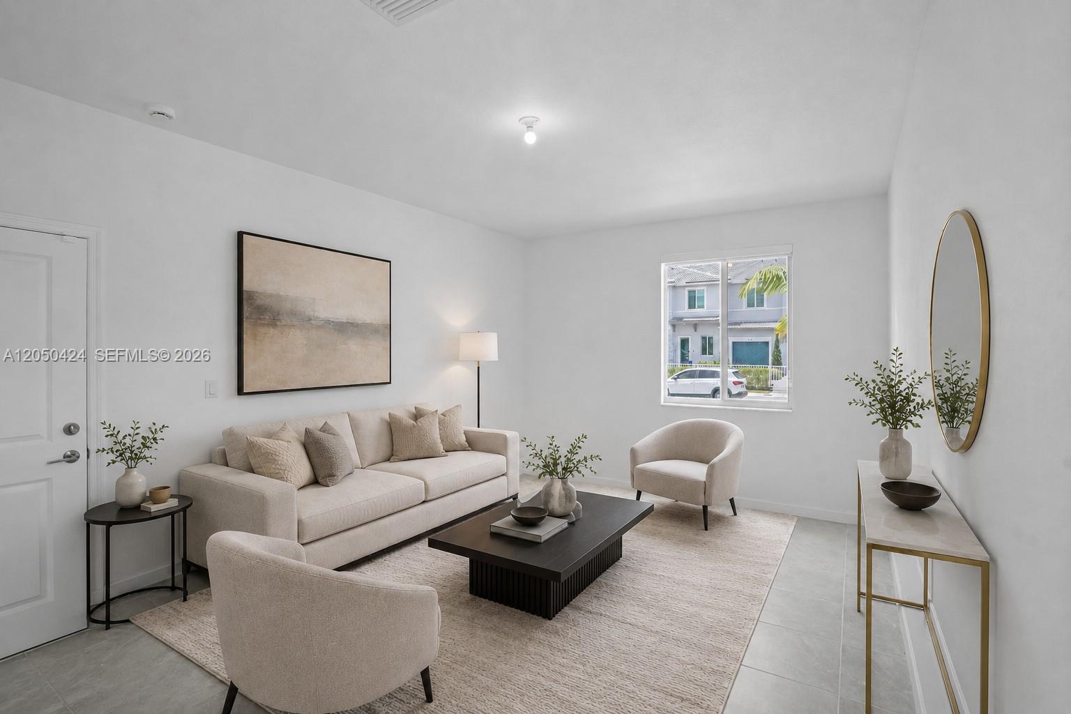 A bright living room features a neutral sofa, two armchairs, a coffee table, and tile flooring — 715 SE 15th St, Homestead FL 33034, HOMESTEAD, FL