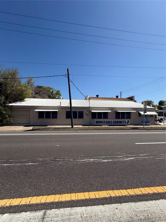 A single-story commercial building with a white metal roof and a wholesale cabinets sign — 225 S DIXIE FREEWAY, NEW SMYRNA BEACH, FL
