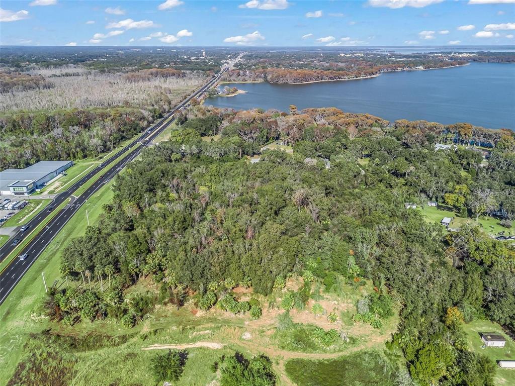 An aerial view of a wooded lot bordering a highway and a large lake — S 14TH STREET, LEESBURG, FL