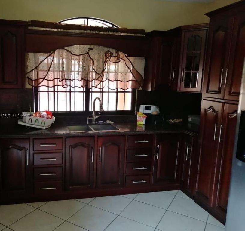 A kitchen features dark wood cabinets, a double sink, and a window with a valance — 0000 Calle Principal Guinope, FL, FL