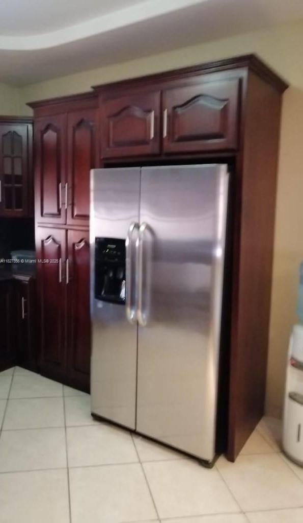 A stainless steel refrigerator is built into dark wood cabinetry in a tiled kitchen — 0000 Calle Principal Guinope, FL, FL