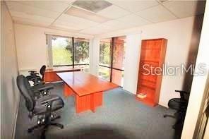 An office room features a large wooden desk, rolling chairs, and a tall wooden bookshelf — 3185 CONWAY ROAD UNIT D, ORLANDO, FL