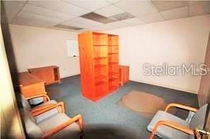 An office room with blue carpet, a wooden bookshelf, and two chairs — 3185 CONWAY ROAD UNIT D, ORLANDO, FL