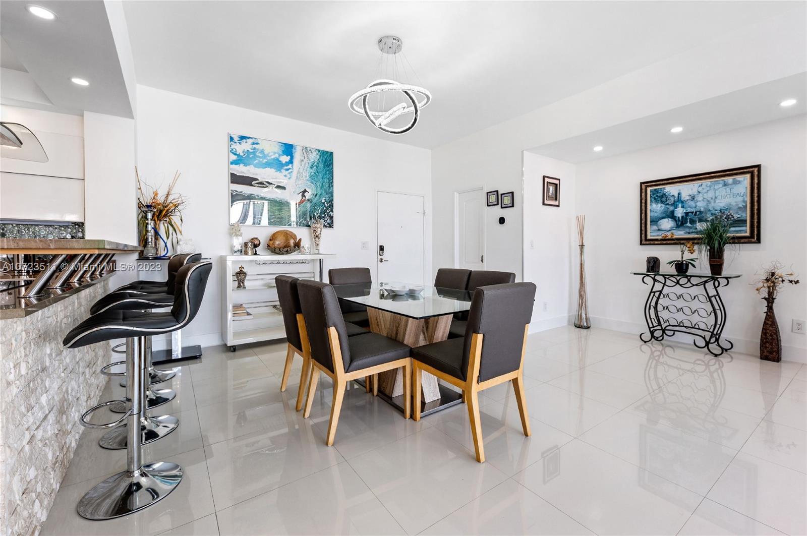 A dining area with a glass table, dark chairs, and a breakfast bar with stools — 4001 S Ocean Dr, Hollywood FL 33019, HOLLYWOOD, FL