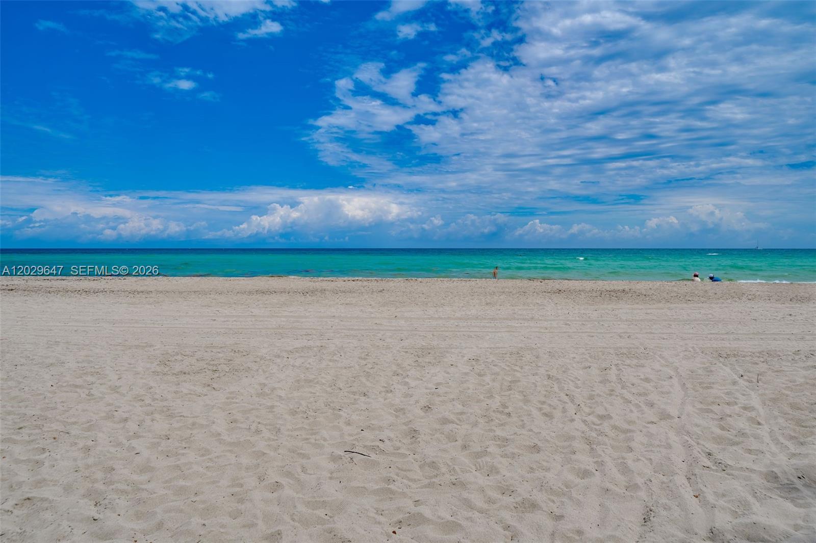 A wide, sandy beach meets the turquoise ocean under a bright, cloudy blue sky — 1201 S Ocean Dr # 1105N, Hollywood FL 33019, HOLLYWOOD, FL