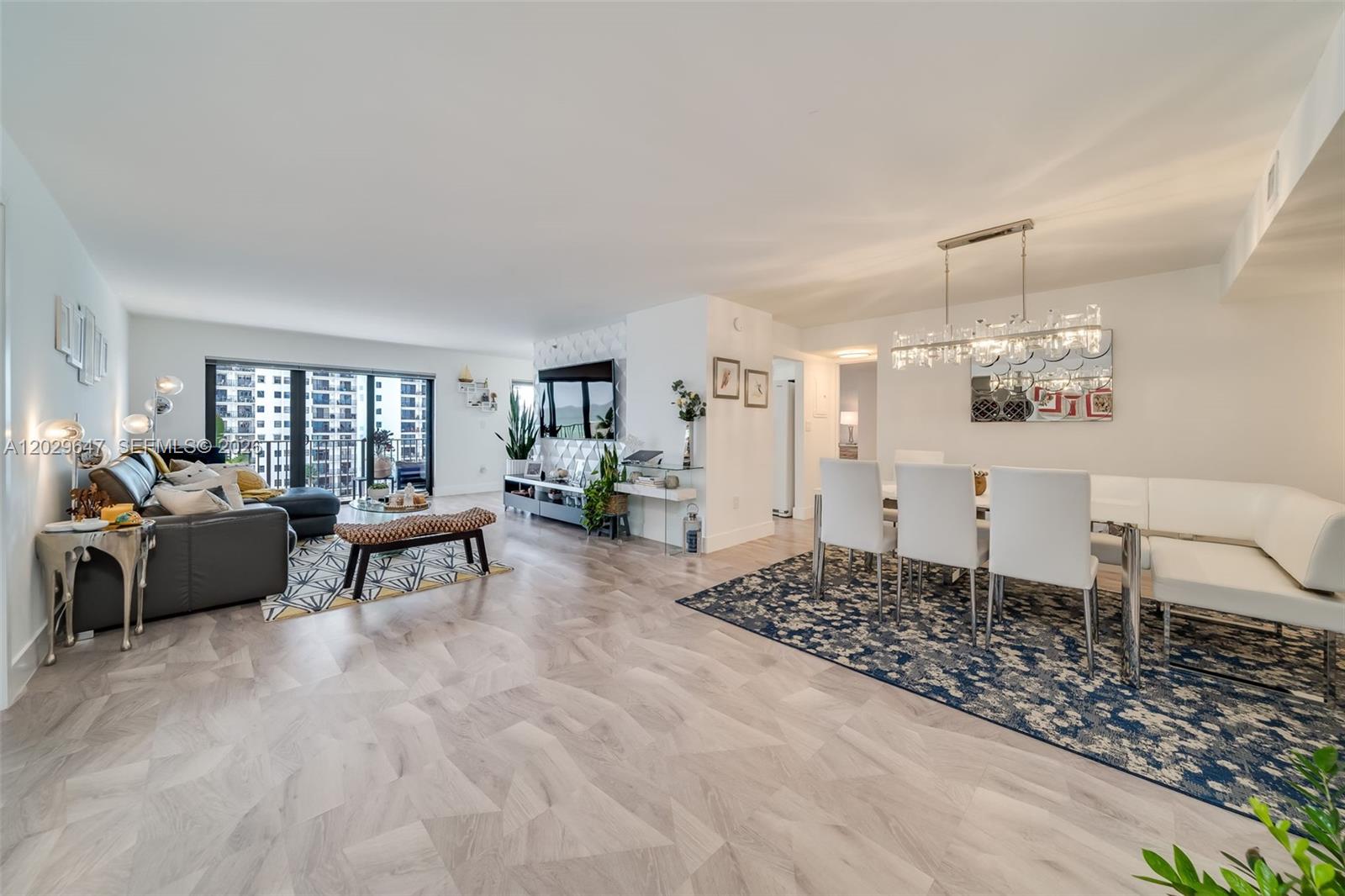 A bright open-concept living and dining area features light wood flooring and modern furniture — 1201 S Ocean Dr # 1105N, Hollywood FL 33019, HOLLYWOOD, FL