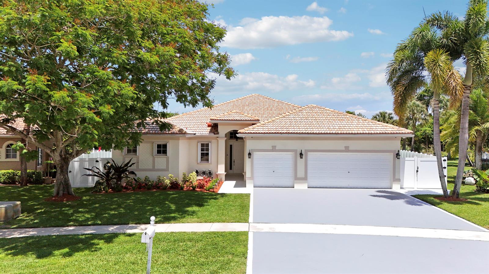 A single-story house with a tiled roof, two-car garage, and a large tree in front — 10075 Freesian Way, Lake Worth FL 33449, LAKE WORTH, FL