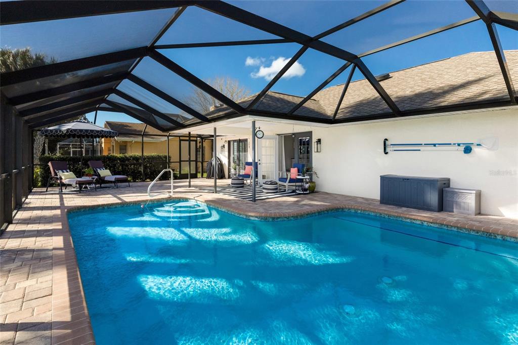 A screened-in patio features a swimming pool, brick pavers, and outdoor seating — 5107 86TH STREET COURT W, BRADENTON, FL