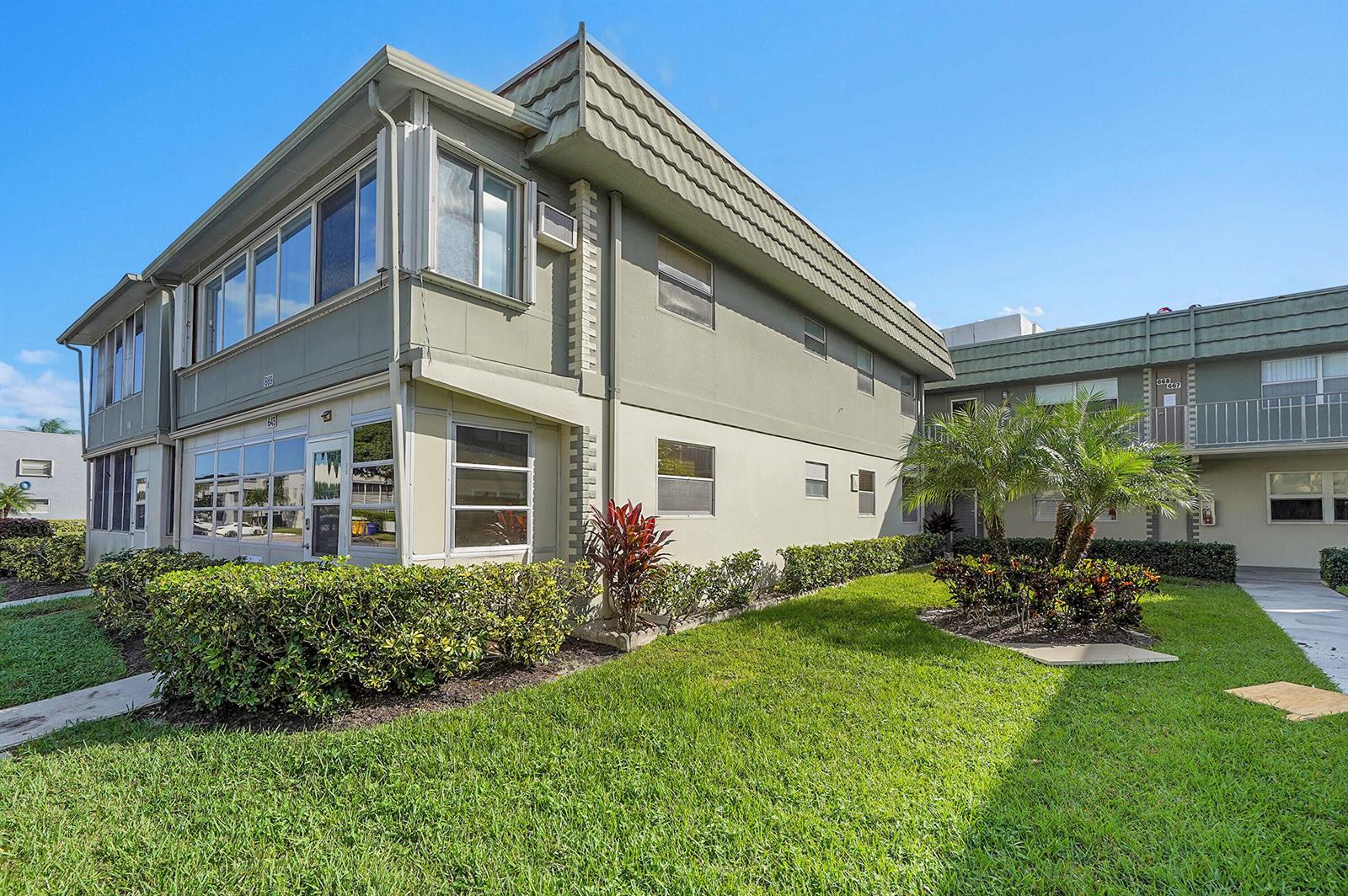A two-story apartment building with light green stucco walls and a landscaped front yard — 646 Flanders N, Delray Beach FL 33484, DELRAY BEACH, FL