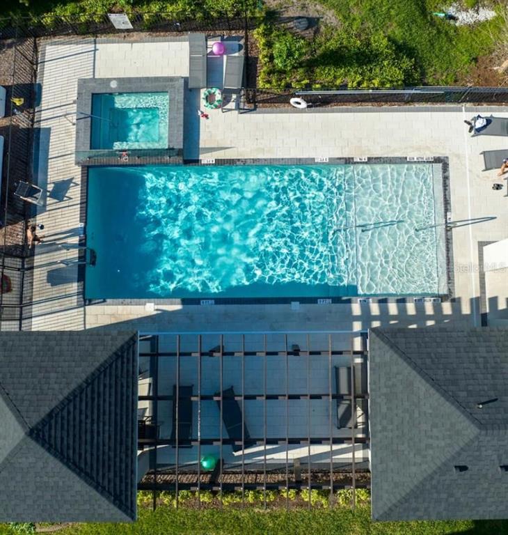 An aerial view shows a rectangular swimming pool, a spa, and a pergola-covered patio area — 4711 TERRA ESMERALDA DRIVE, KISSIMMEE, FL