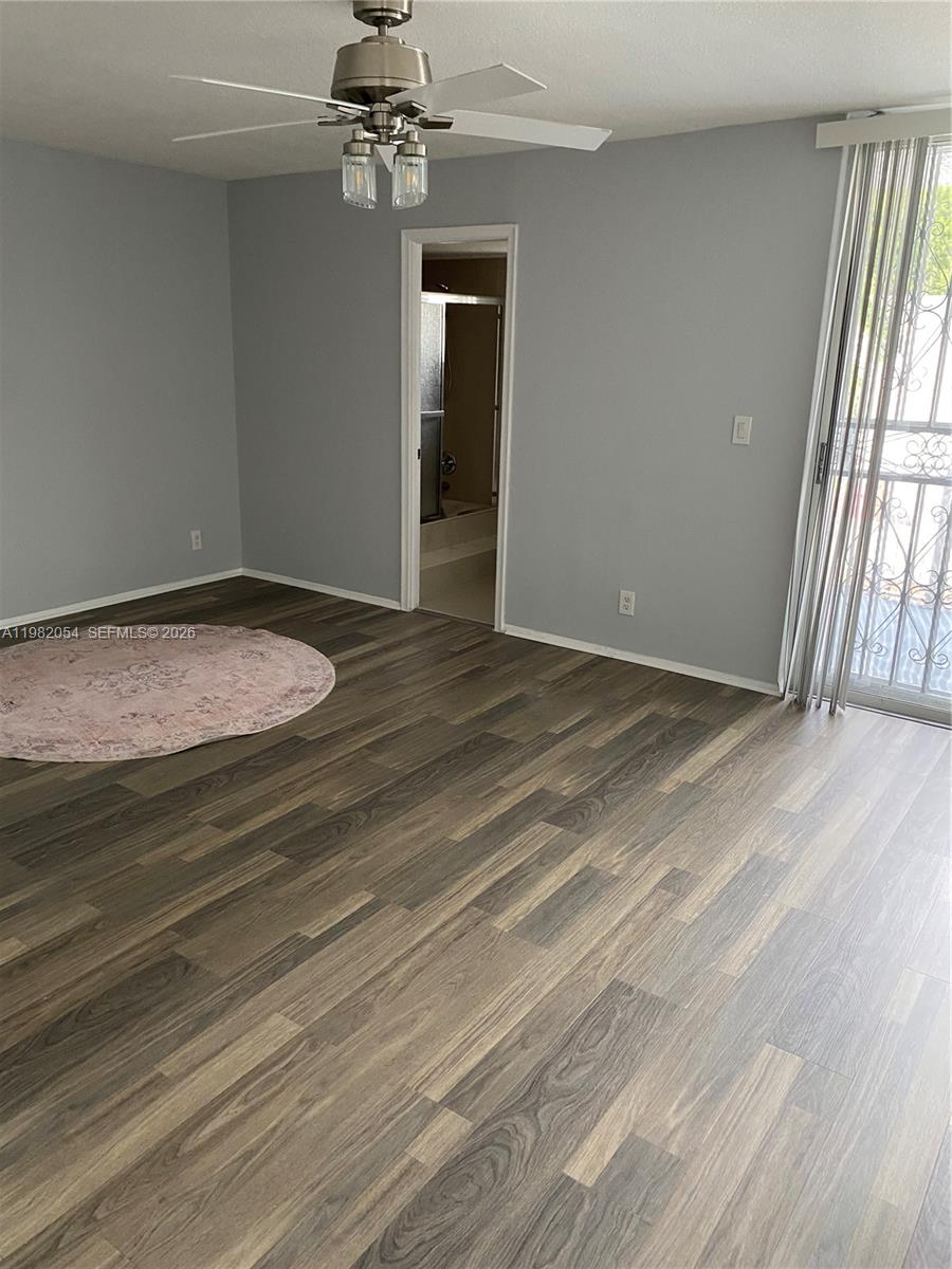 A bedroom features gray walls, wood-look flooring, a ceiling fan, and a sliding glass door — 802 NE 26th Ave # 802, Hallandale Beach FL 33009, HALLANDALE BEACH, FL