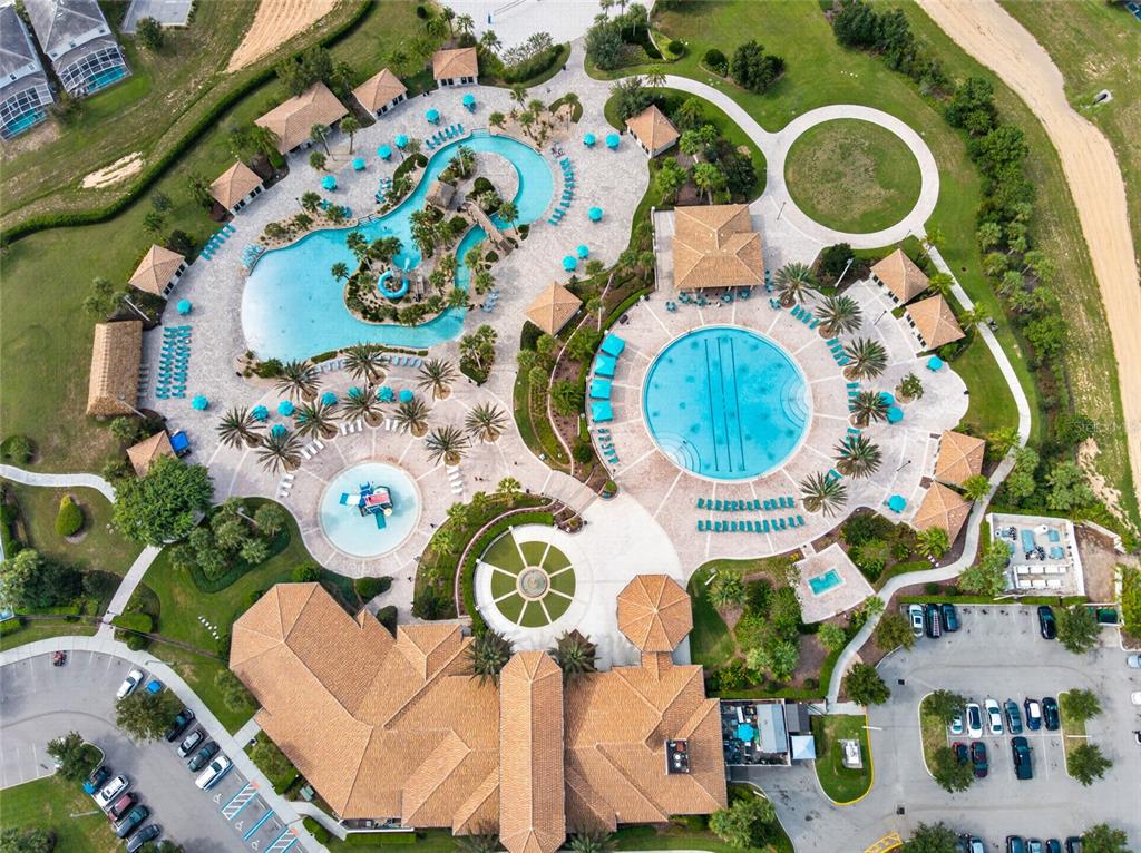An aerial view shows a community pool complex with multiple swimming areas, cabanas, and parking — 8813 BETH PAGE LANE, DAVENPORT, FL