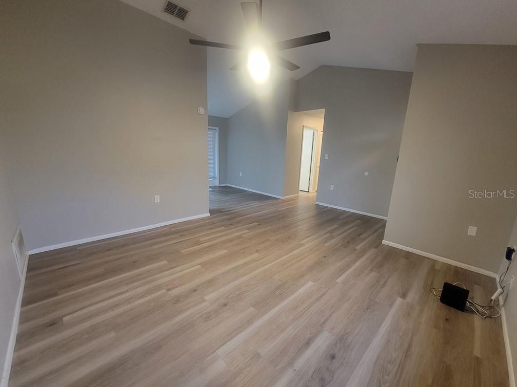 An empty room with light wood-look flooring, gray walls, and a ceiling fan — 1305 CALAMONDIN DRIVE, HOLIDAY, FL