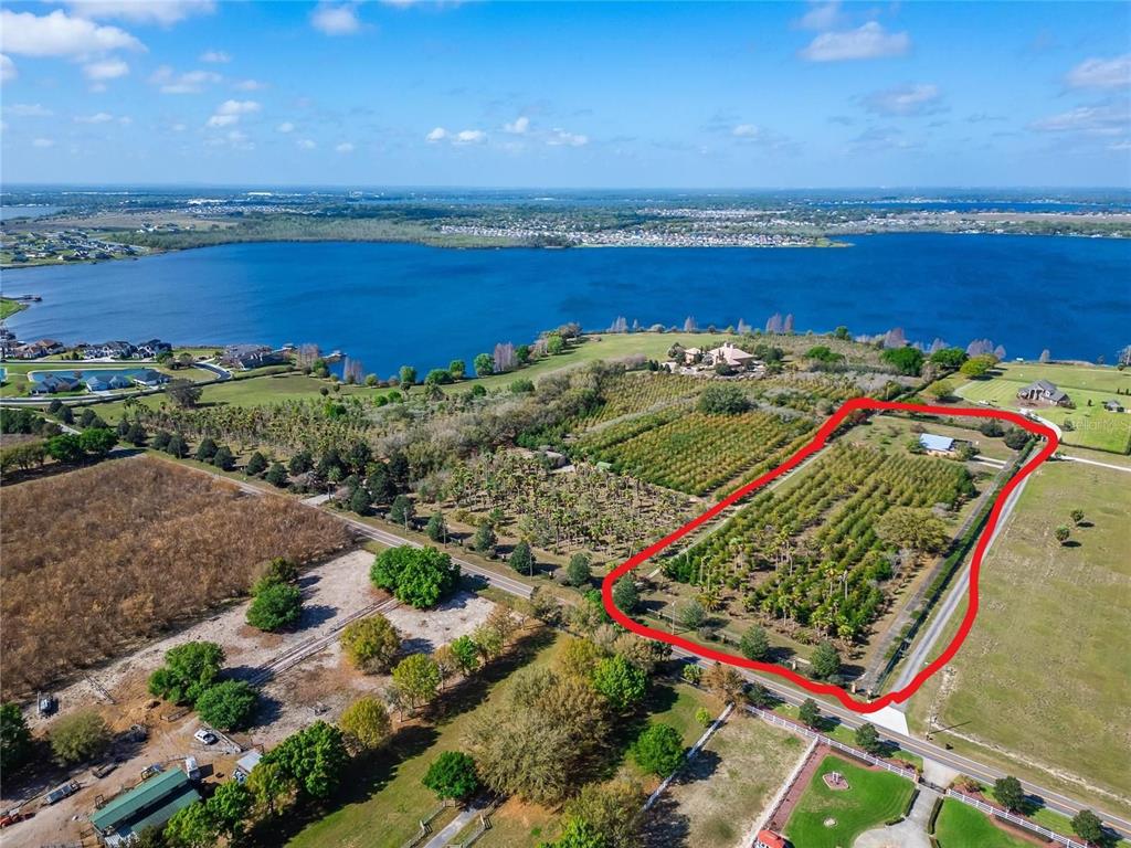 An aerial view shows a rectangular plot of land with trees and a small building — ADAMS BARN ROAD, AUBURNDALE, FL