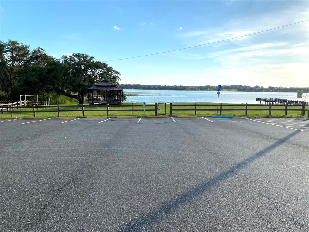A paved parking lot overlooks a lake with a gazebo and a wooden fence — Lots 11.12 SW SHOREWOOD DRIVE, DUNNELLON, FL