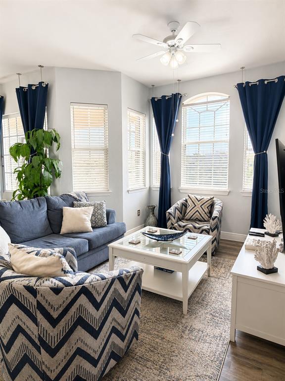 A living room features blue furniture, patterned armchairs, white tables, and navy curtains — 322 TERRACE RIDGE CIRCLE UNIT 322, DAVENPORT, FL