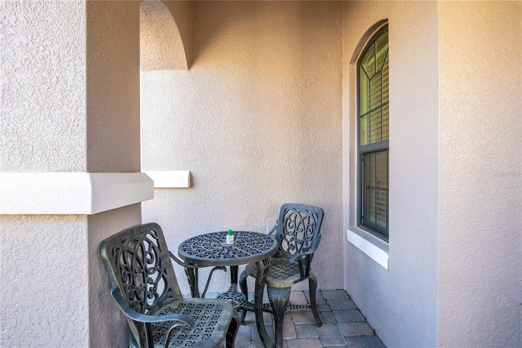 A small covered patio features a metal bistro set on a paved floor — 1282 ZEEK RIDGE STREET, CLERMONT, FL