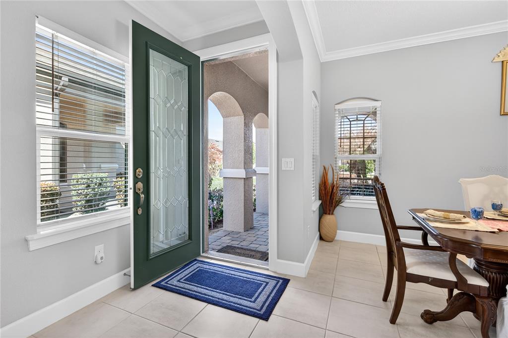 A dining area with tile floors, a dark green front door, and a view outside — 1282 ZEEK RIDGE STREET, CLERMONT, FL
