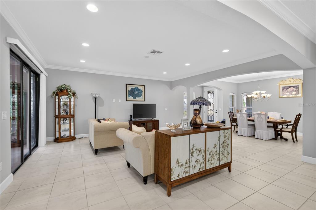 A living room with tile flooring, neutral walls, and a dining area in the background — 1282 ZEEK RIDGE STREET, CLERMONT, FL