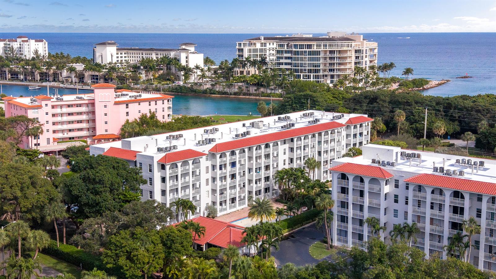 An aerial view shows several multi-story apartment buildings with red tile roofs near water — 950 Ponce De Leon # 3120, Boca Raton FL 33432, BOCA RATON, FL
