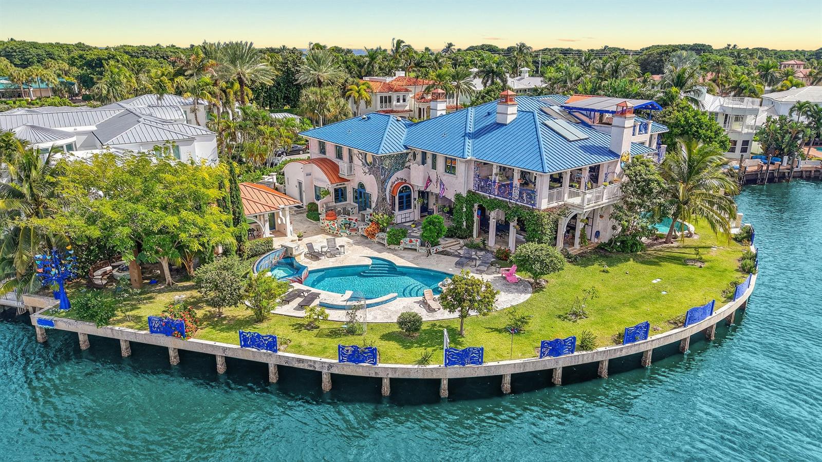 An aerial view of a waterfront house with a blue roof, pool, and landscaped yard — 1201 Marble Way, Boca Raton FL 33432, BOCA RATON, FL