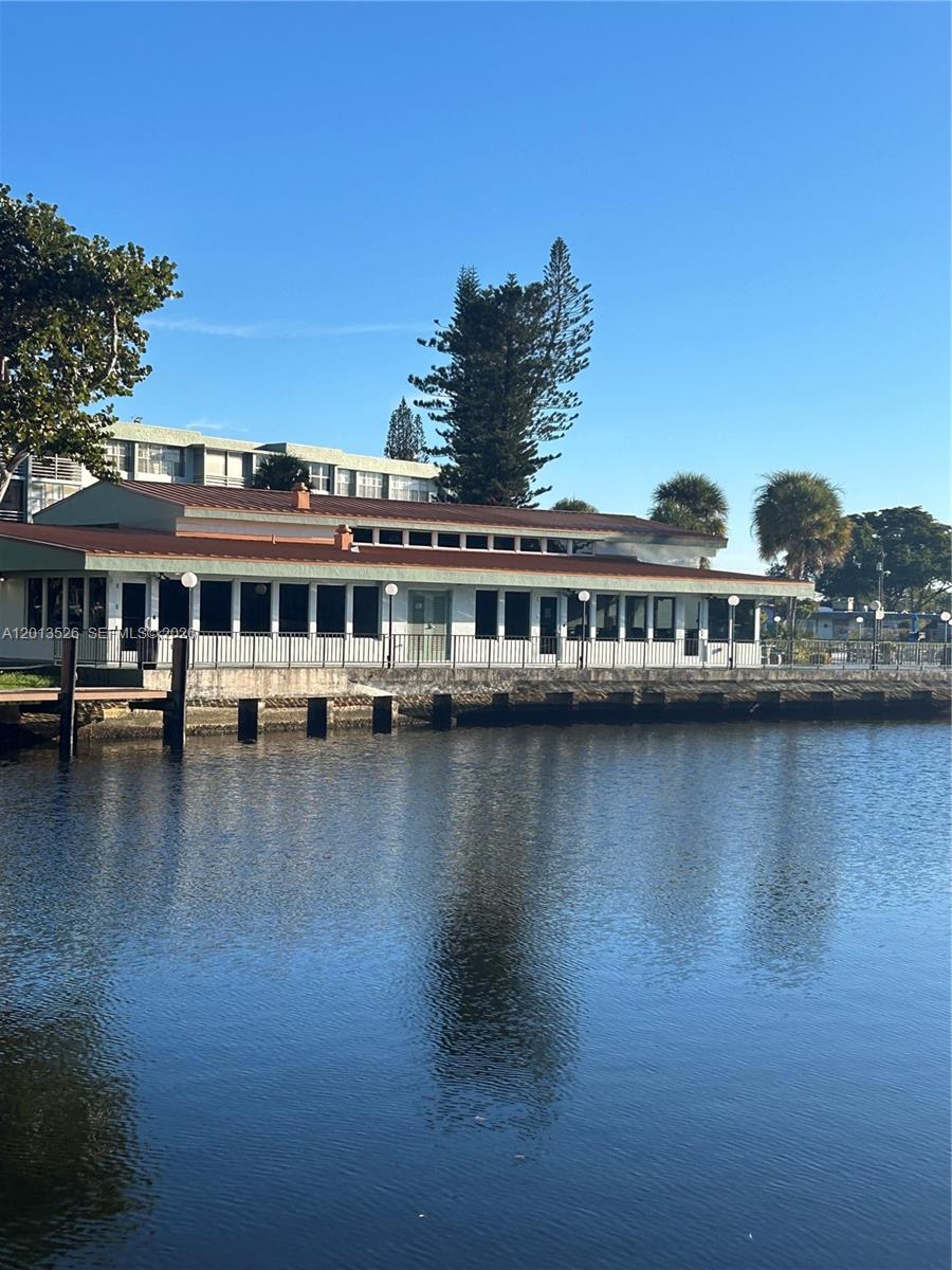 A low-rise building with a white exterior sits along a waterfront bulkhead — 2741 Taft St # 203, Hollywood FL 33020, HOLLYWOOD, FL