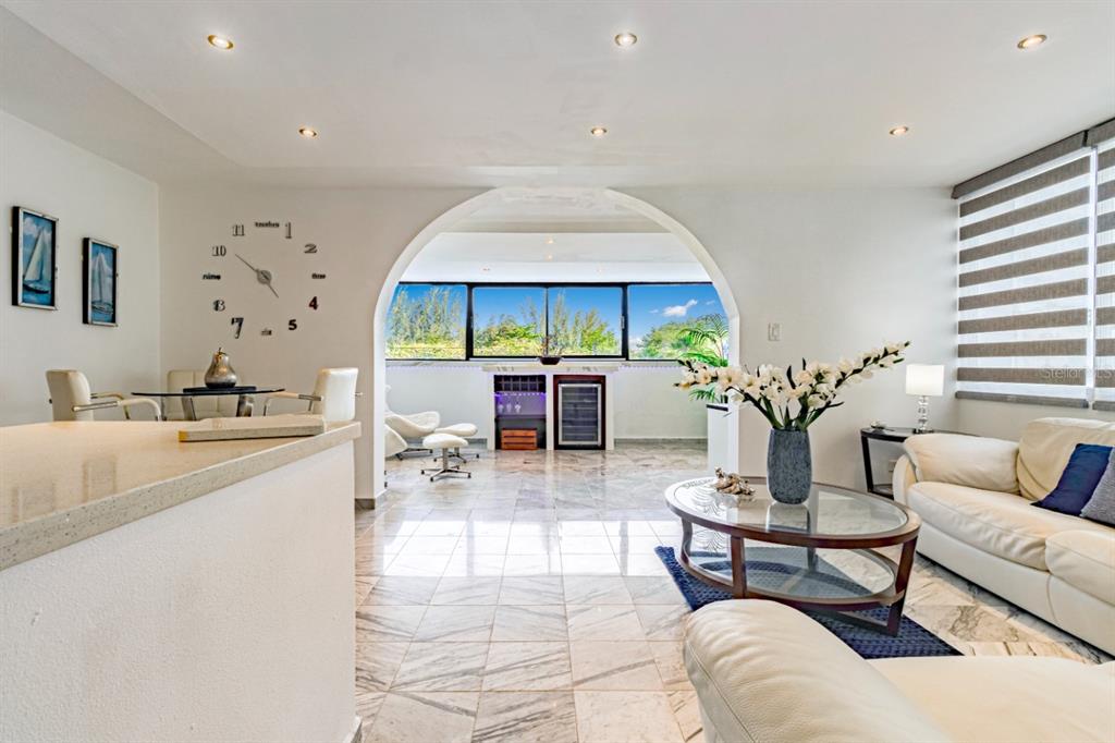 A living room with marble floors, a large arched opening, and a built-in wine cooler — 7185 COND. MAR DE ISLA VERDE UNIT 3A, CAROLINA, PR