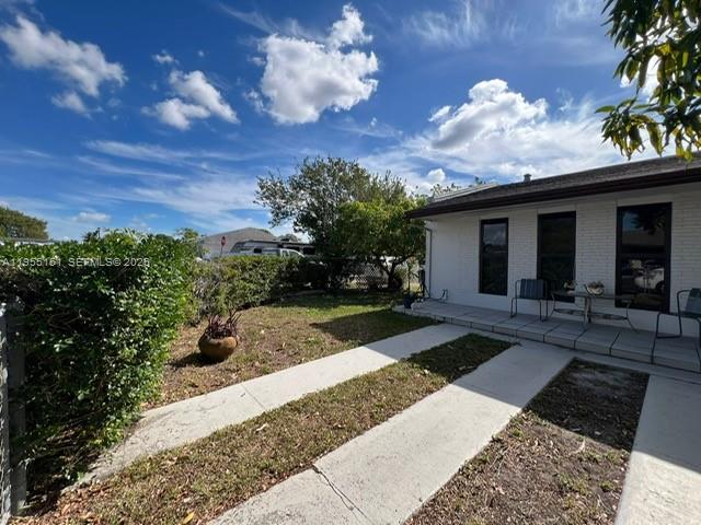 A white brick house features a concrete walkway leading to a covered patio area — 13002 SW 48th St, Miami FL 33175, MIAMI, FL