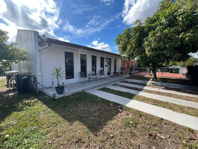 A white, single-story house features a covered front patio and a paved driveway — 13002 SW 48th St, Miami FL 33175, MIAMI, FL