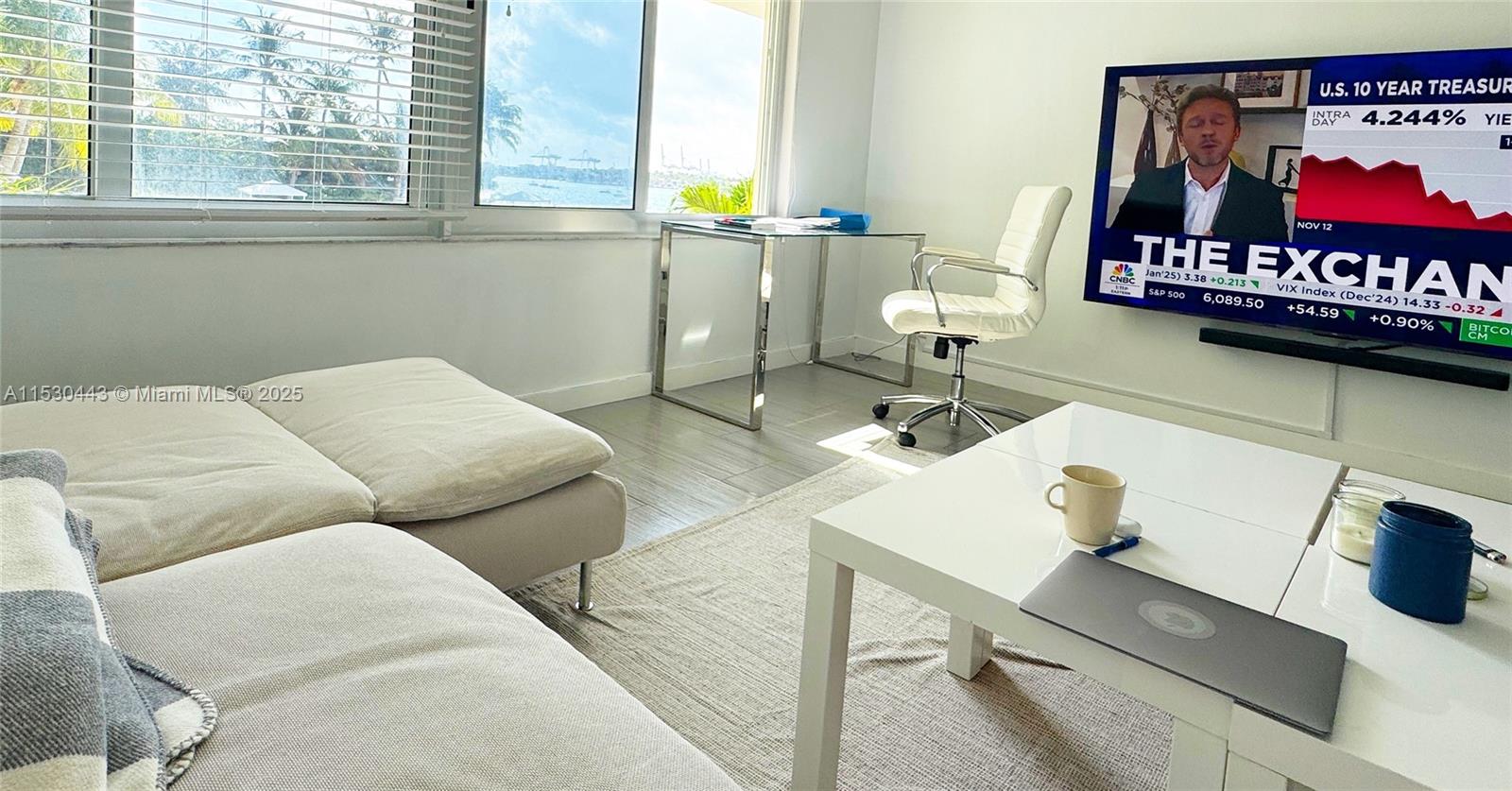 A living room features a white sofa, a coffee table, a desk, and a television — 1200 West Ave # 202, Miami Beach FL 33139, MIAMI BEACH, FL