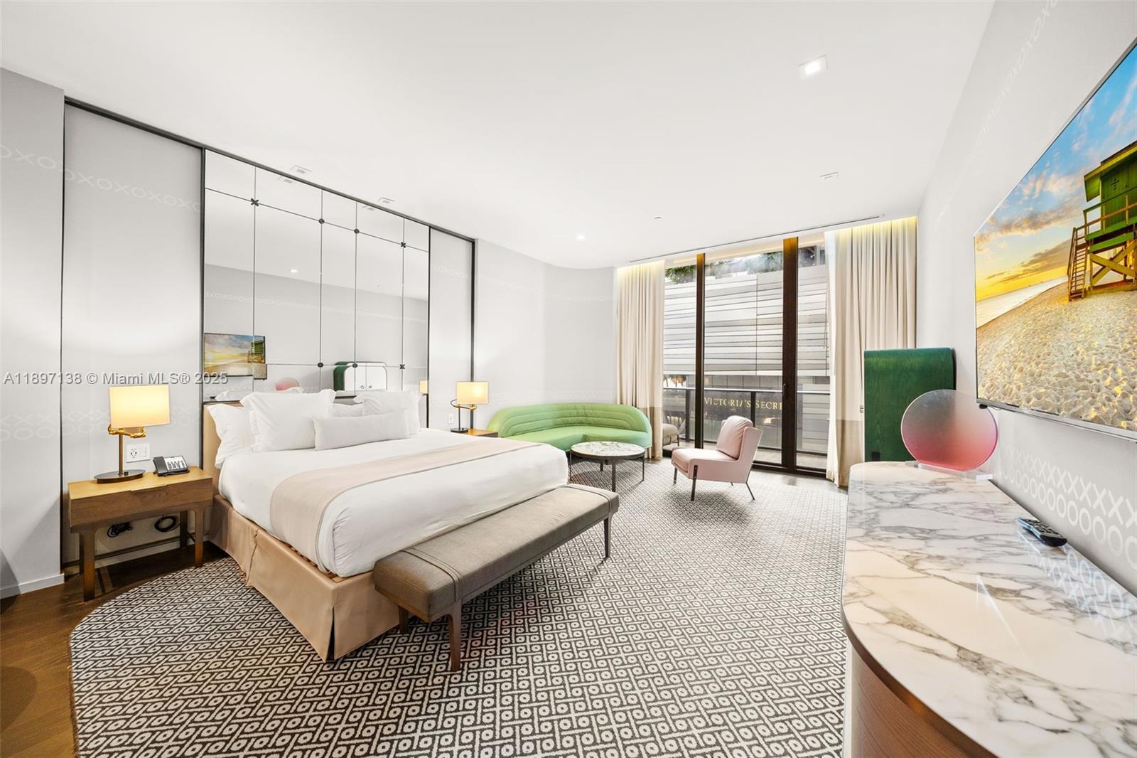 A modern bedroom features a mirrored wall, a king bed, and a marble-topped console — 801 S Miami Ave # 402, Miami FL 33130, MIAMI, FL