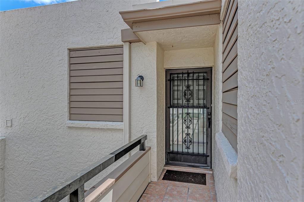 An exterior view shows a recessed entryway with a security door and a metal railing — 346 SPRINGDALE DRIVE W UNIT 346, BRADENTON, FL