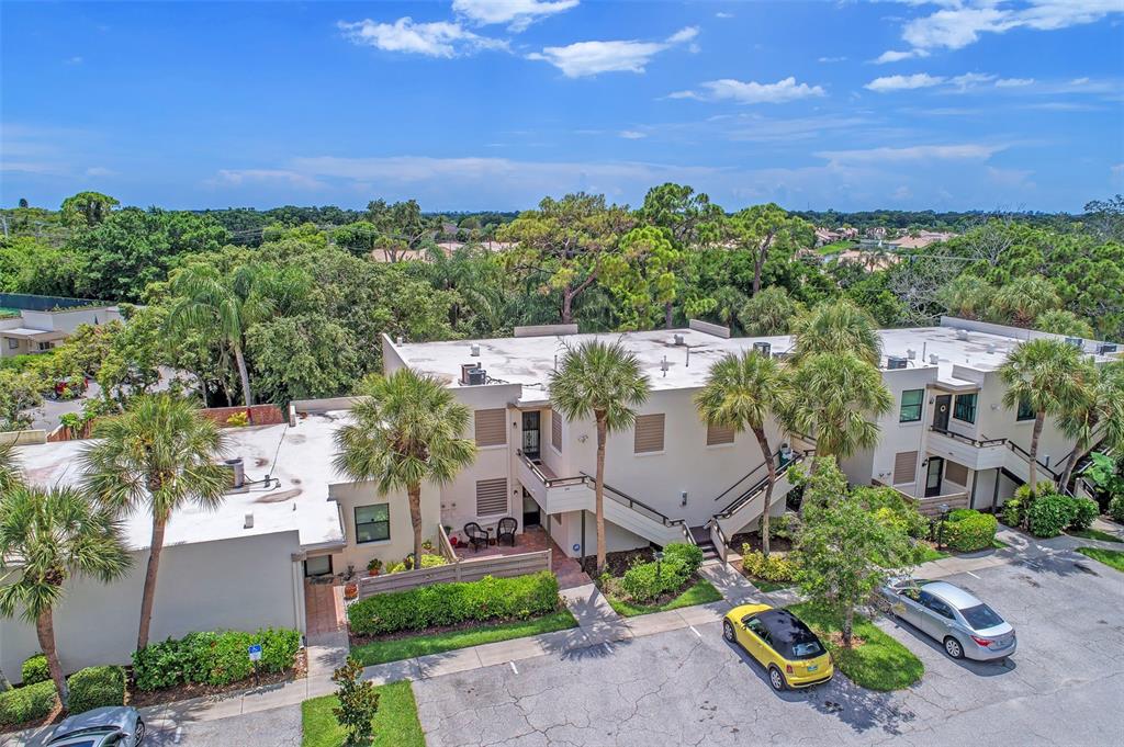 An aerial view of a two-story apartment building with palm trees and a parking lot — 346 SPRINGDALE DRIVE W UNIT 346, BRADENTON, FL