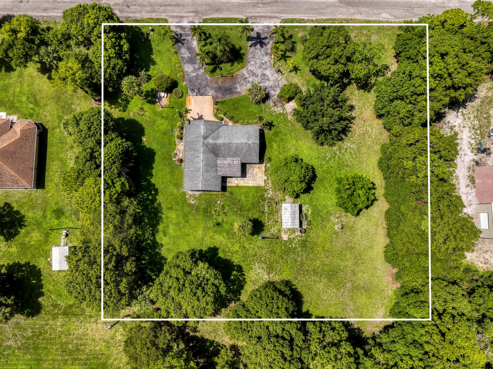 An aerial view shows a house with a gray roof, driveway, and yard within a lot — 7107 181st Street N, Jupiter FL 33458, JUPITER, FL