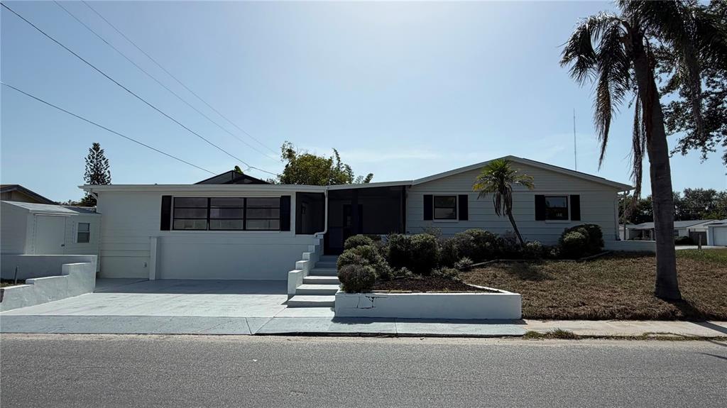 A single-story white house with black shutters and a front yard sign — 3708 HOLIDAY LAKE DRIVE, HOLIDAY, FL
