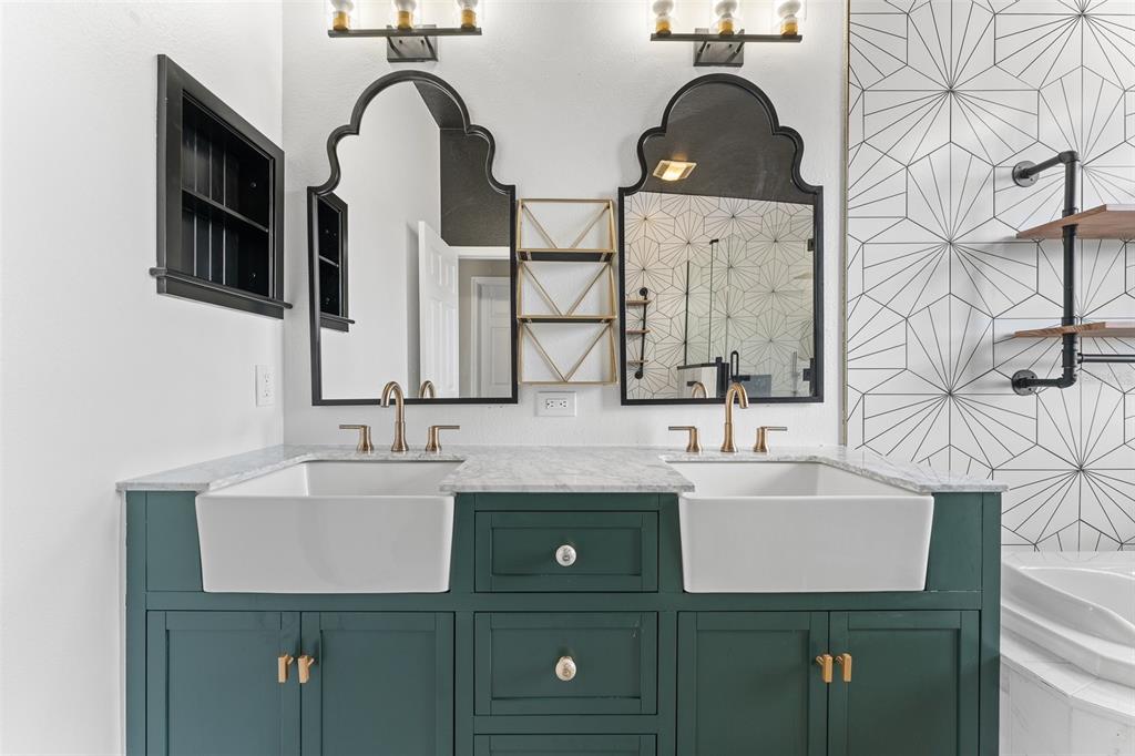A bathroom features a dual-sink vanity with teal cabinets, marble countertops, and arched black mirrors — 1291 BLACKRUSH DRIVE, TARPON SPRINGS, FL