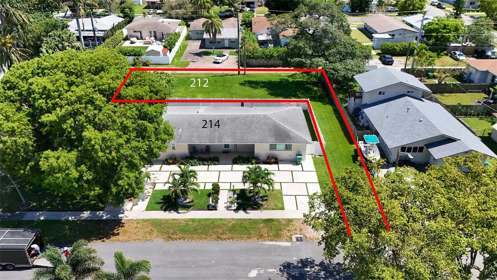 An aerial view shows a residential property with a house and a large grassy lot — 212 SE 5th Street, Dania Beach FL 33004, DANIA BEACH, FL