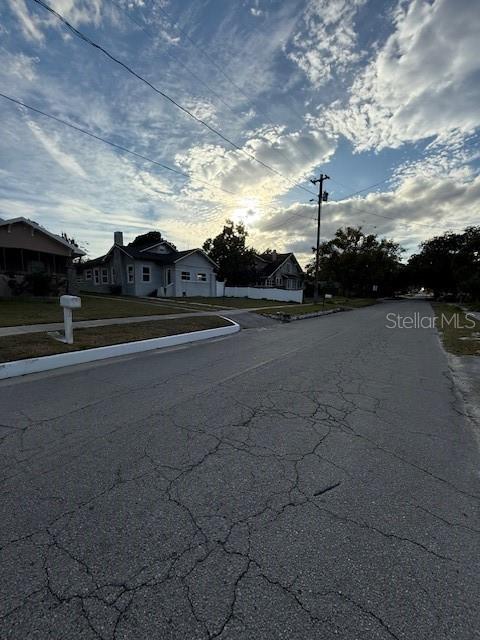 A street view shows residential houses under a cloudy sky with a utility pole — 414 AVENUE C AVENUE NE, WINTER HAVEN, FL