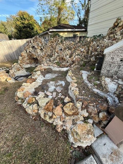A backyard garden features a stone-built miniature village structure with a small water feature — 414 AVENUE C AVENUE NE, WINTER HAVEN, FL